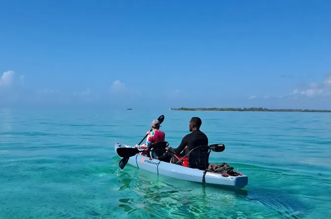 Kayakers paddling toward a reef platform on a small-group Nassau Bahamas snorkeling adventure