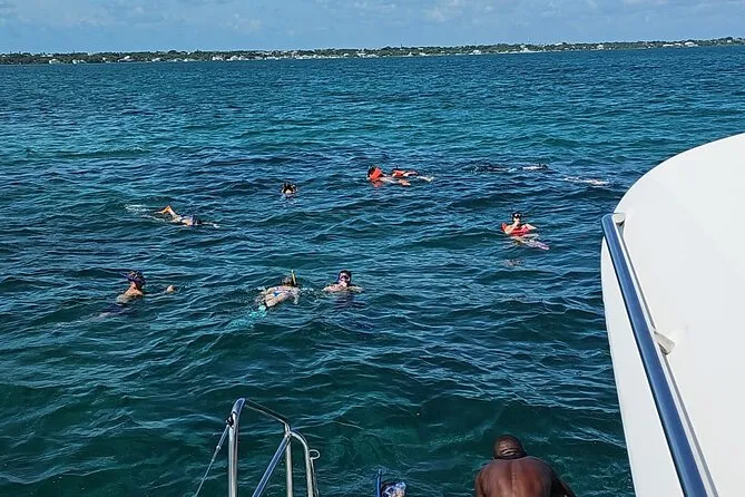 Snorkelers floating over a shallow coral reef on a Nassau Bahamas snorkeling tour near Rose Island