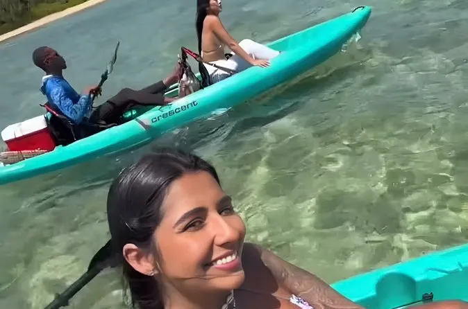 Kayakers paddling toward a coral reef on a small-group Nassau Bahamas snorkeling adventure to a secluded beach in Nassau